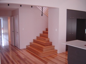 Stained timber flooring with staircase.