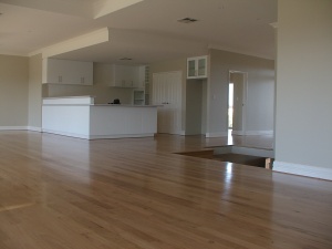 Lounge room and kitchen with timber floors.